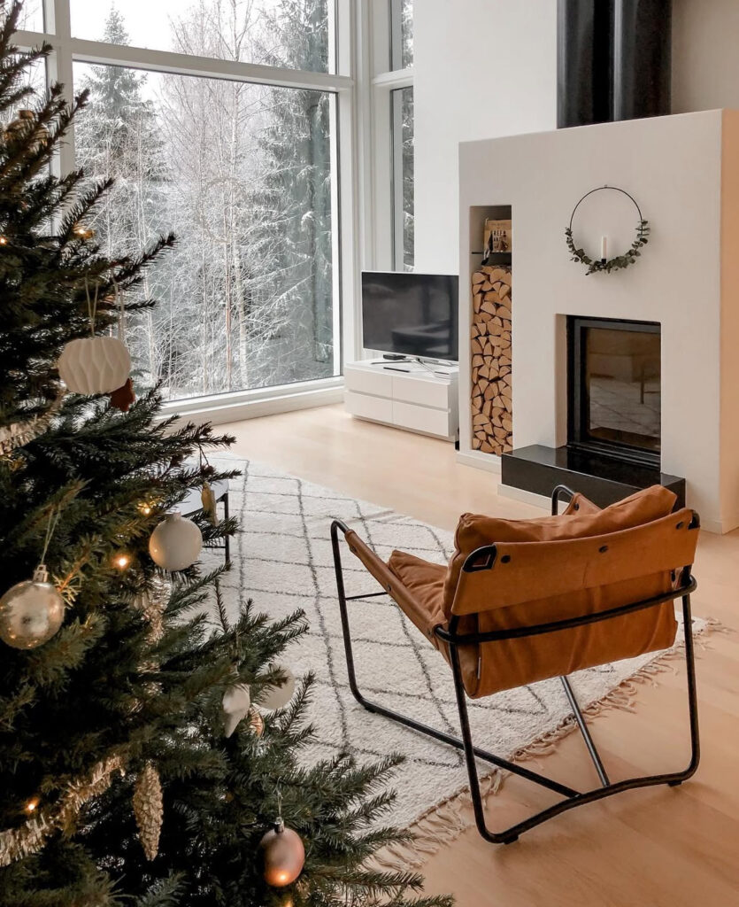 Scandinavian fireplace hearth with forest view and Christmas decor