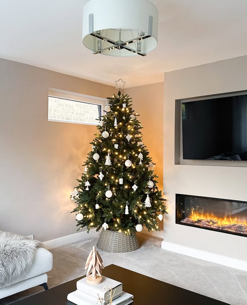 minimalist Christmas tree beside a modern fireplace
