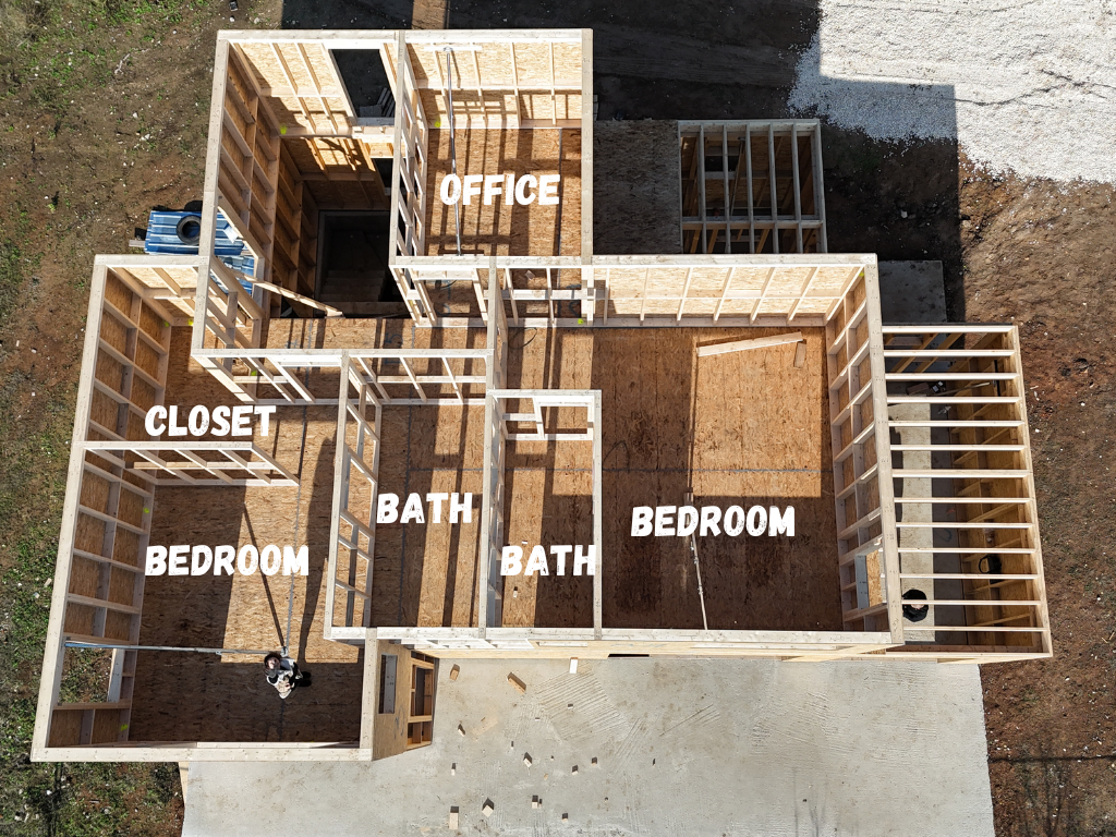 Top-down view of a partially framed house with room labels showing bedrooms, bathrooms, a closet, and an office