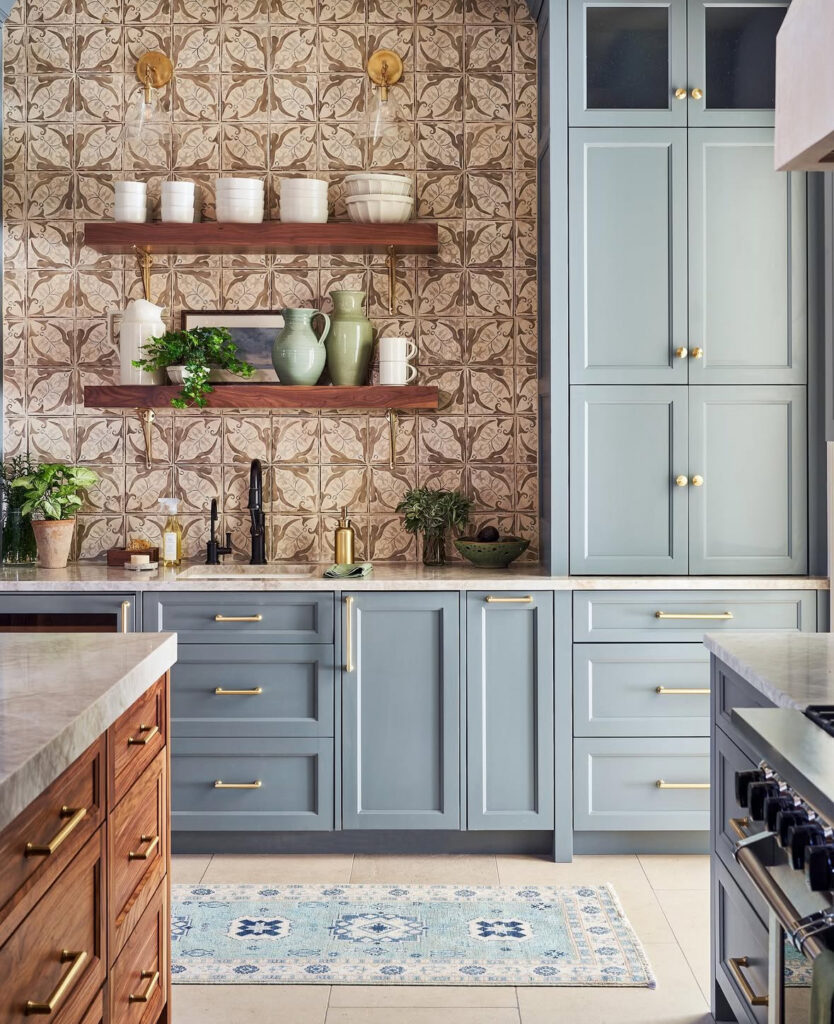 blue cabinetry patterned tile warm wood shelving colorful rustic lake house kitchen with brass accents
