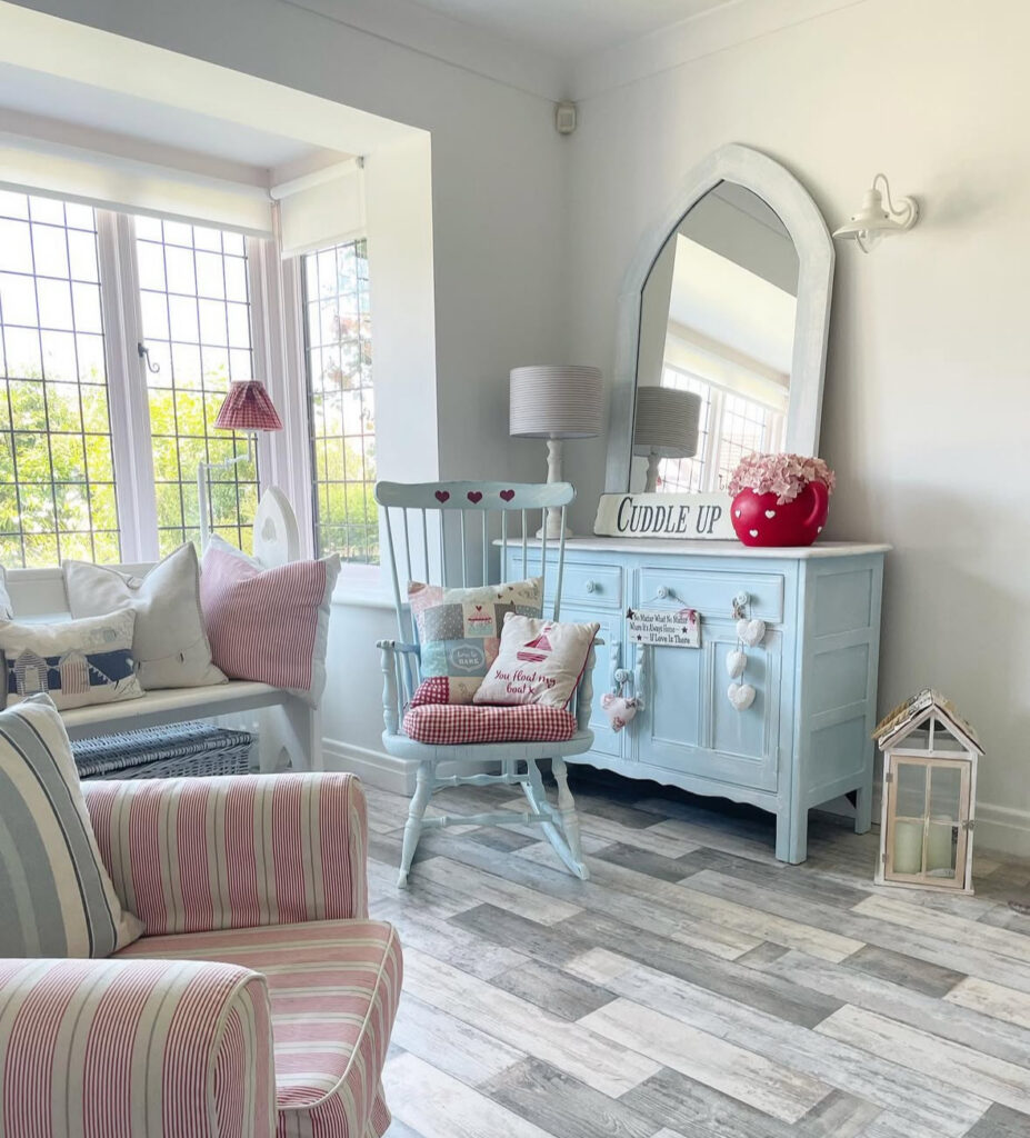 Light-filled sitting room with blue sideboard and striped chairs for charming shabby chic decor ideas.