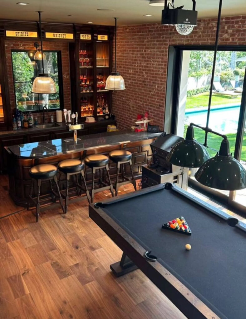 A brick back bar and black pool table showcase stylish basement man cave ideas with a pub-inspired feel.