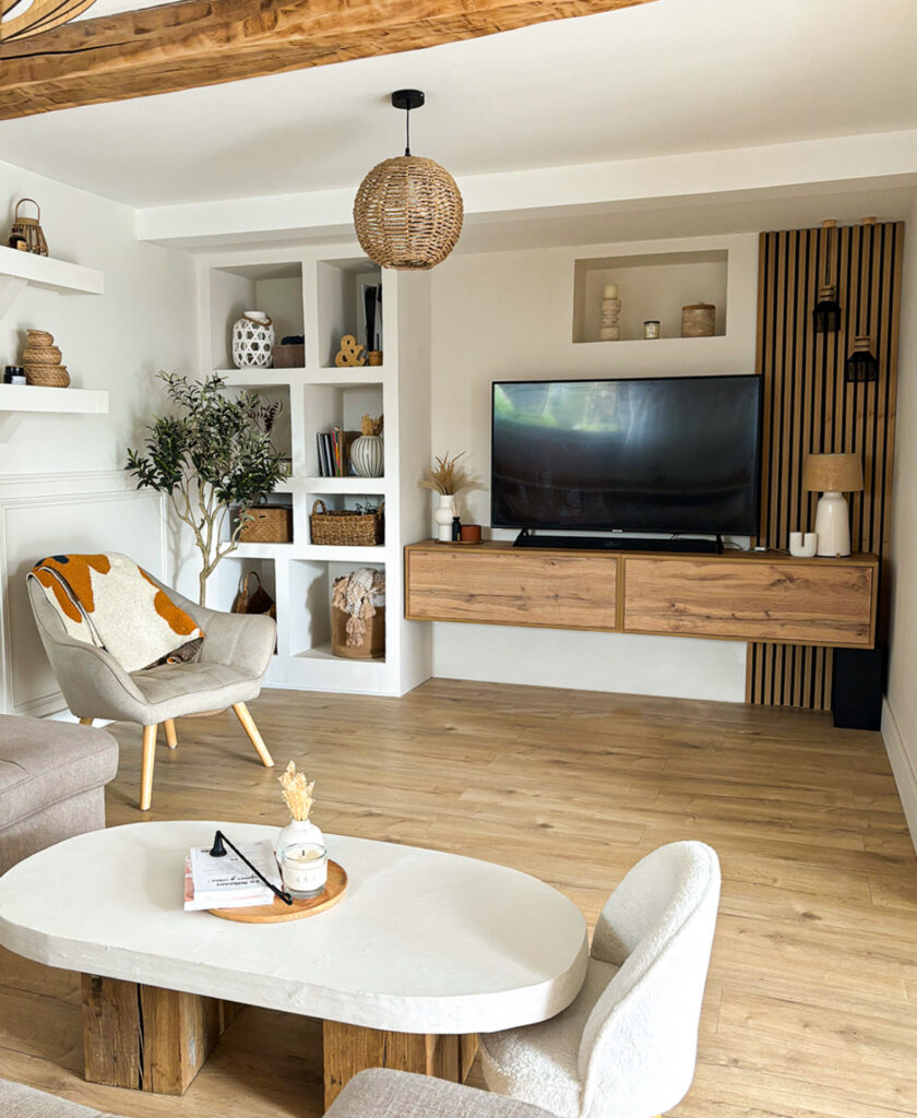 built-in shelving, wood media unit, and framed art creating cozy tv wall ideas for living room spaces full of books and decor.