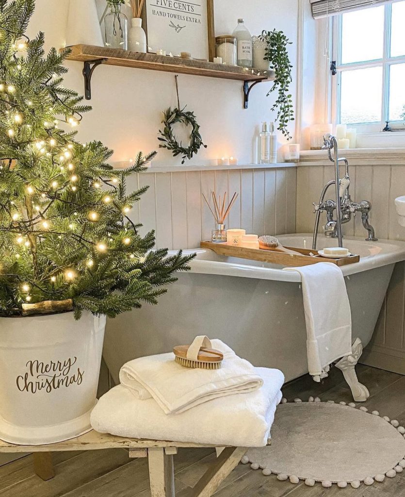 Clawfoot tub bathroom decorated with candles for Christmas
