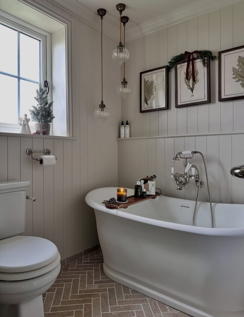 Cottage-style bathroom decorated with candles and Christmas accents