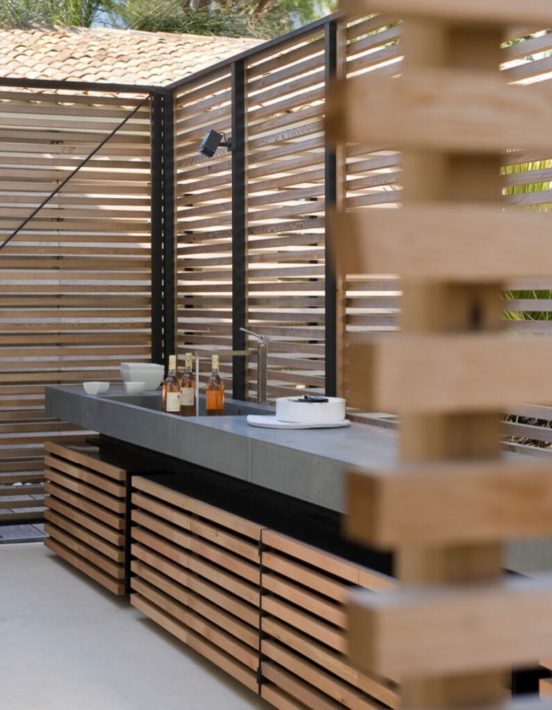Concrete counter with wood slat walls creating a chic yet cheap simple outdoor kitchen zone