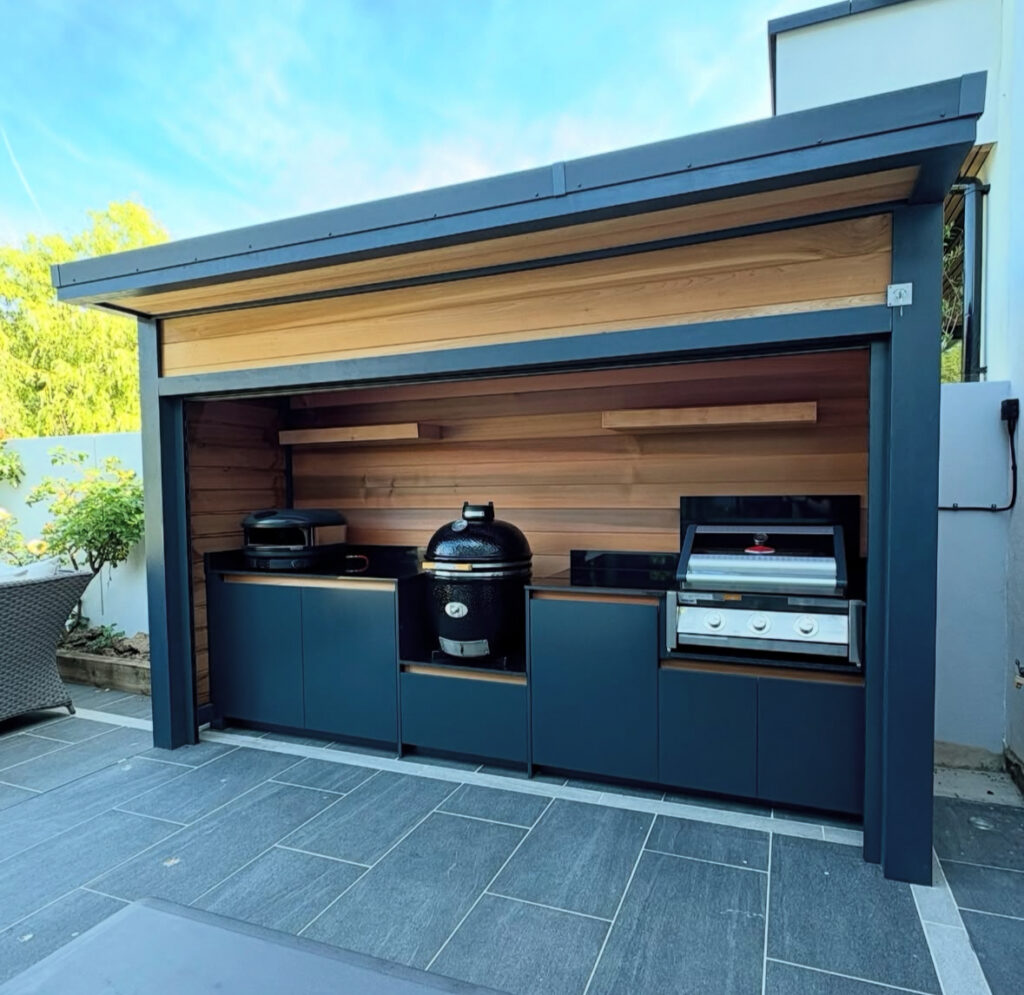 Modern shelter with cedar back wall housing flat-top, kamado, and gas grills for versatile outdoor kitchen ideas