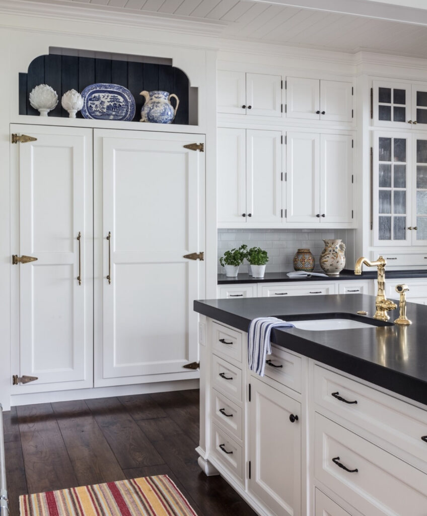 traditional white cabinetry dark counters blue and white pottery accents classic lake house kitchen