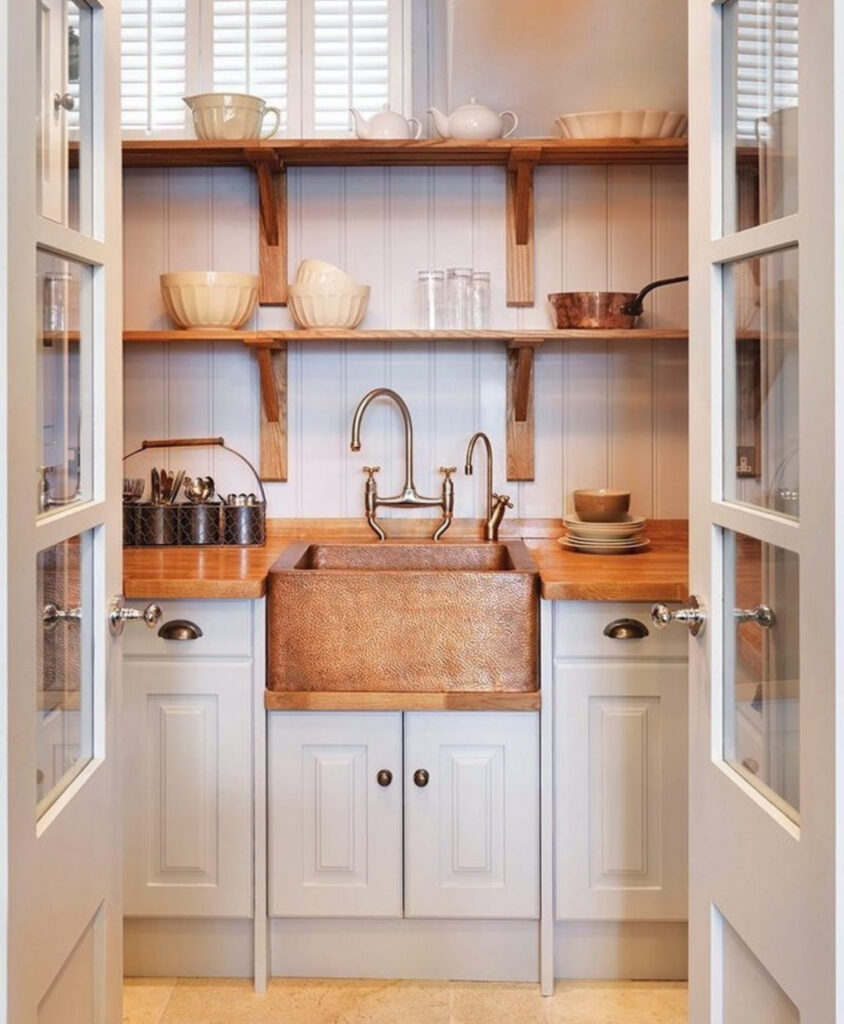 tiny scullery with a hammered copper sink pale cabinets and open wood shelves offers charming small walk in pantry ideas