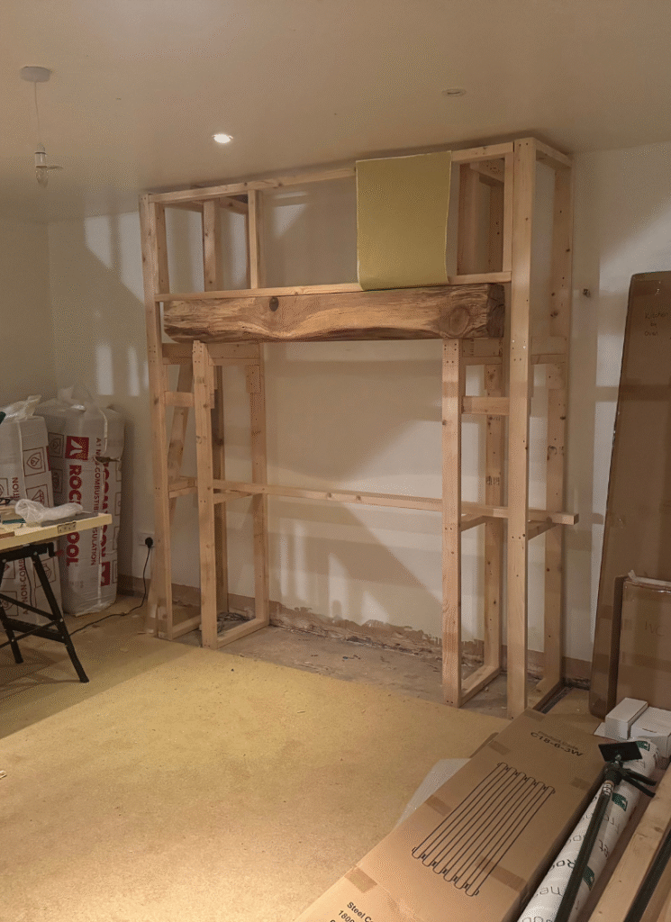 Timber frame structure for a faux inglenook fireplace being built, sharing DIY barn conversion ideas for custom built-ins.