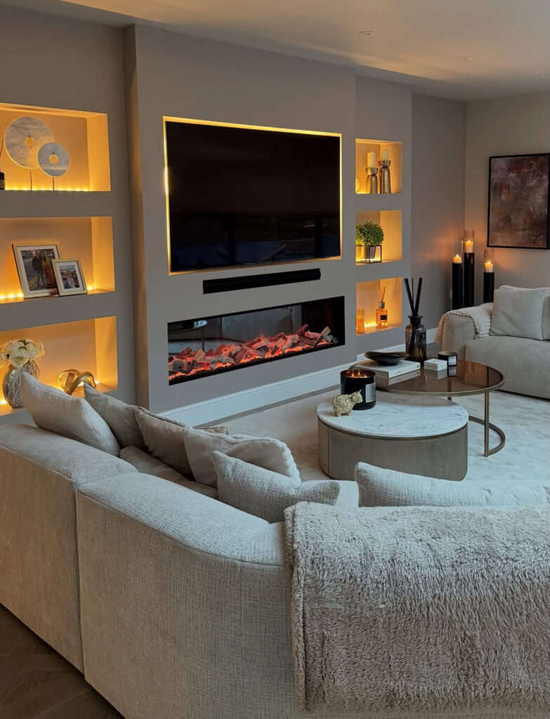 Contemporary fireplace wall with TV, recessed display shelves, and amber lighting offering tv wall decoration ideas for living room spaces that double as cozy retreats.