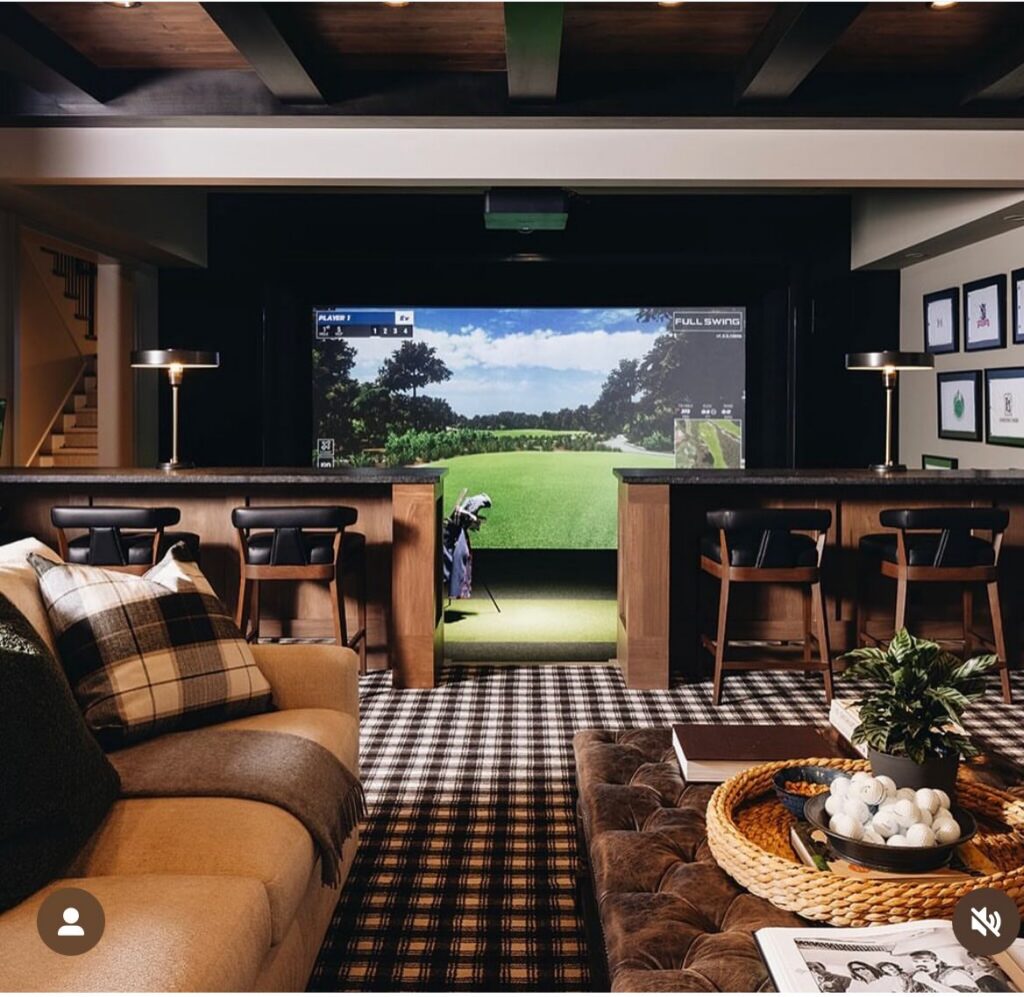 A golf simulator, plaid carpet, and bar seating deliver upscale sports man cave ideas that blend practice with entertaining.