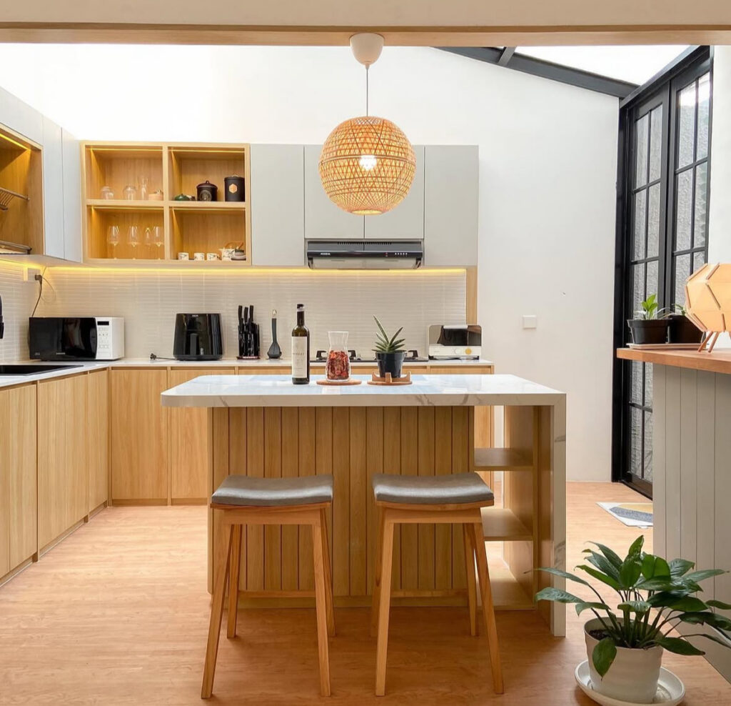 Small Japandi kitchen island illuminated by a rattan pendant light.
