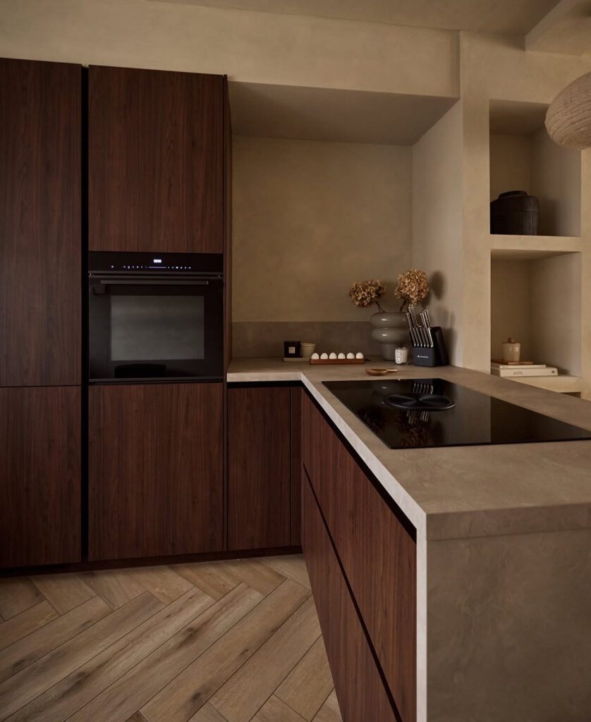 Dark walnut Japandi kitchen set against smooth plaster walls.