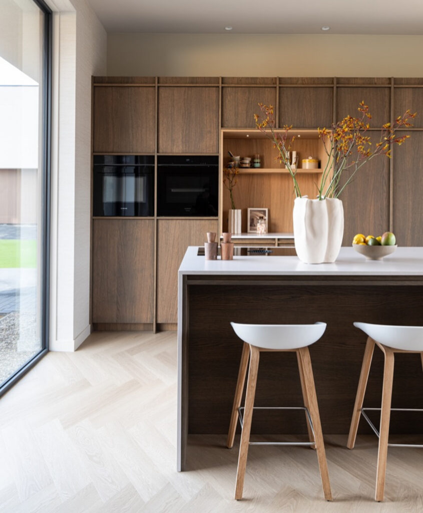 Japandi kitchen with walnut feature wall and matching island.