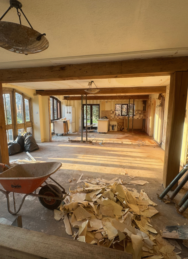 Open-plan room mid-demolition with piles of rubble and old kitchen units, illustrating barn conversion ideas at the gut-renovation stage.