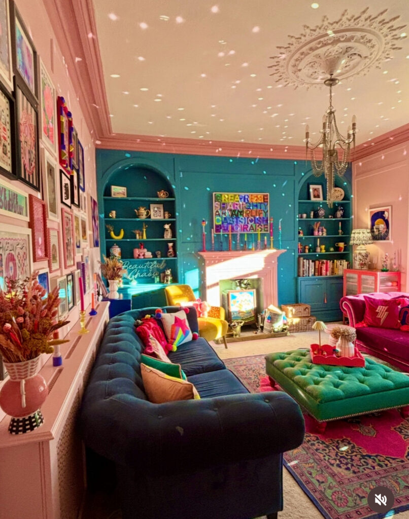 Vibrant living room with blue built-ins, pink accents, and velvet sofas — a maximalist dream of modern eclectic home decor.