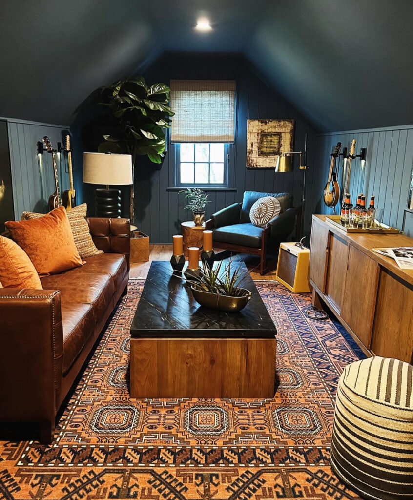 Guitars, a leather sofa, and patterned rug show how small man cave ideas can turn a tucked-away loft into a music retreat.
