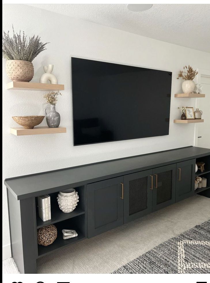 Matte charcoal console with styled floating shelves and large mounted screen, simple living room wall ideas with tv that still feel curated.