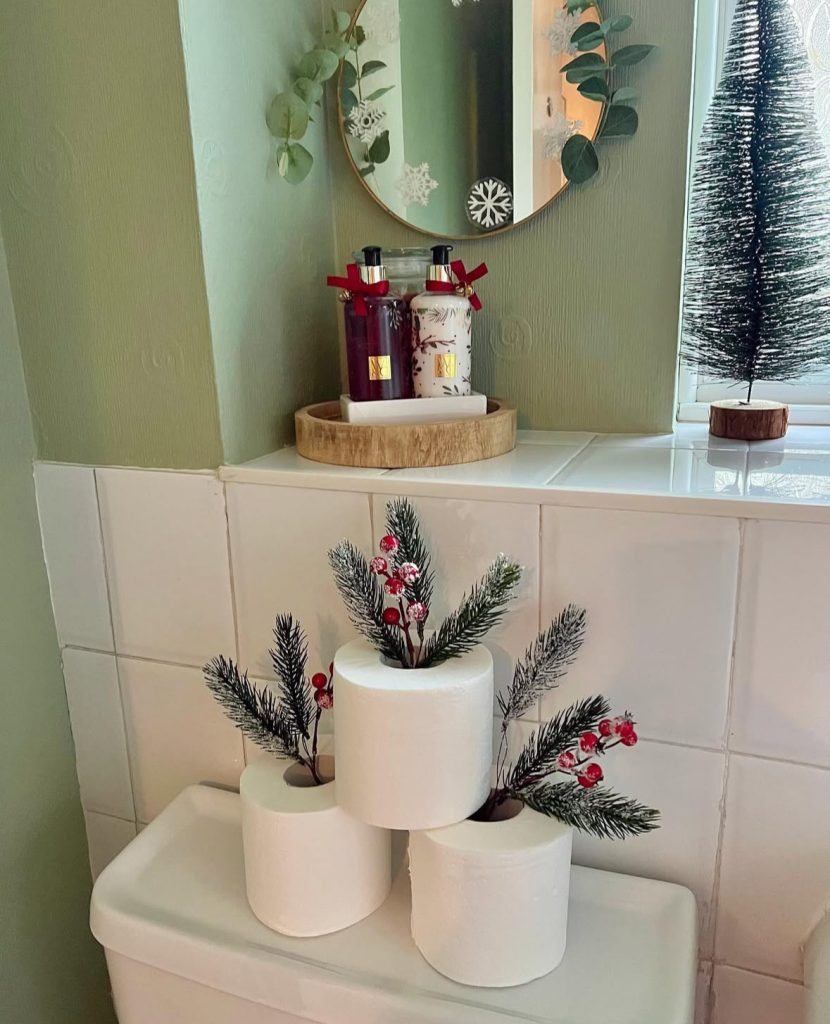 Bathroom with toilet paper arranged as a Christmas tree topiary