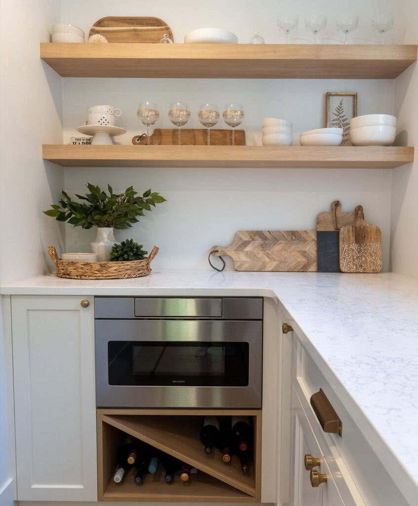 compact u shaped room with marble look counters floating shelves and built in appliances functions as an entertainer friendly walk in pantry with countertop