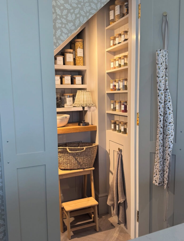 clever under stairs shelving labeled jars and a tiny lamp showcase small walk in pantry ideas in a cozy nook