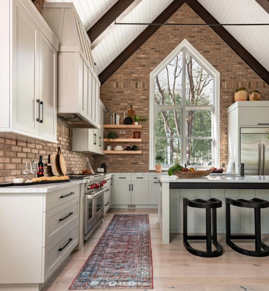vaulted ceiling brick feature wall pale cabinetry warm kitchen ideas for lake house great room large windows
