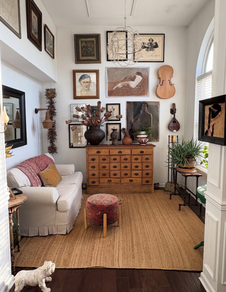 Cozy sitting room with natural rug, framed art, and antique dresser, a quiet ode to vintage eclectic home decor and collected treasures.