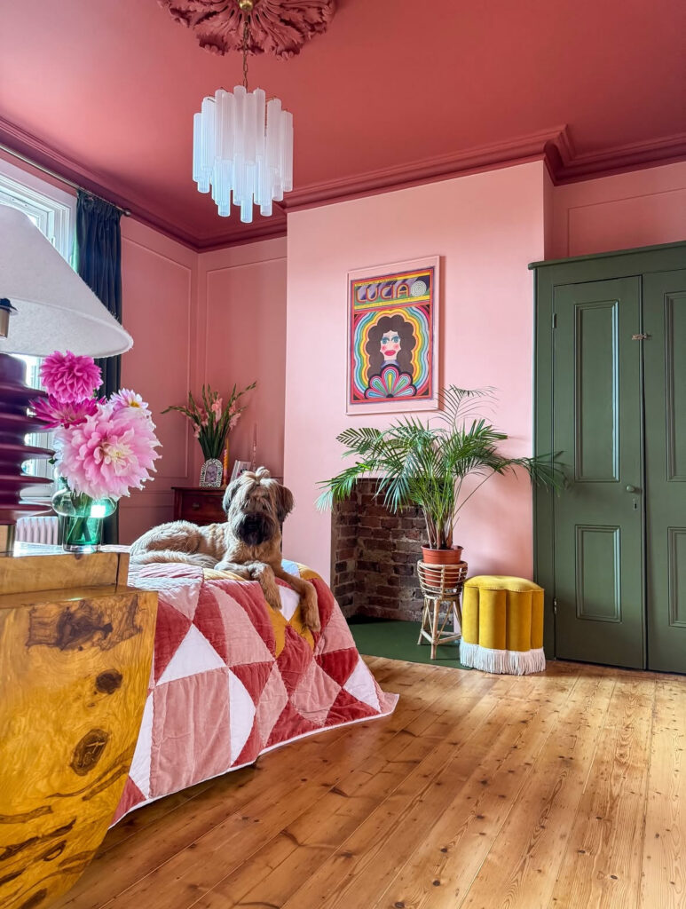 Retro pink bedroom with green wardrobe, bold ceiling color, and quilted bedding — pure vintage eclectic home decor flair.