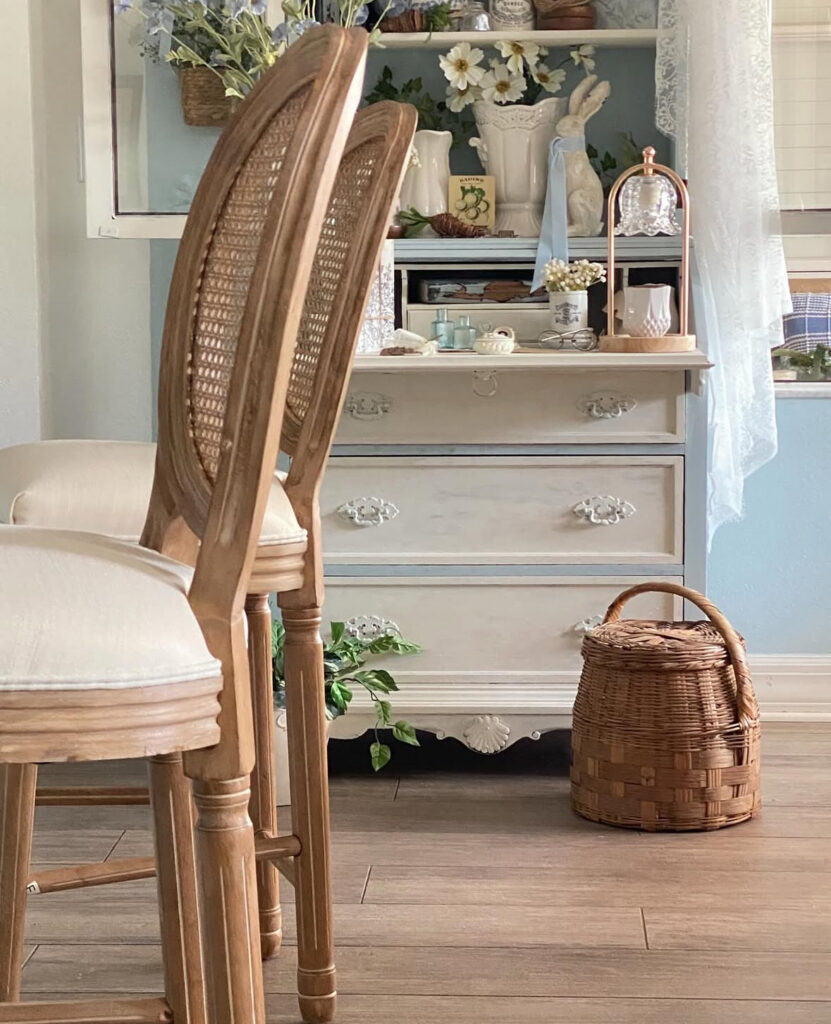 Wood bar stools and vintage sideboard styled with flowers as relaxed shabby chic decor ideas.