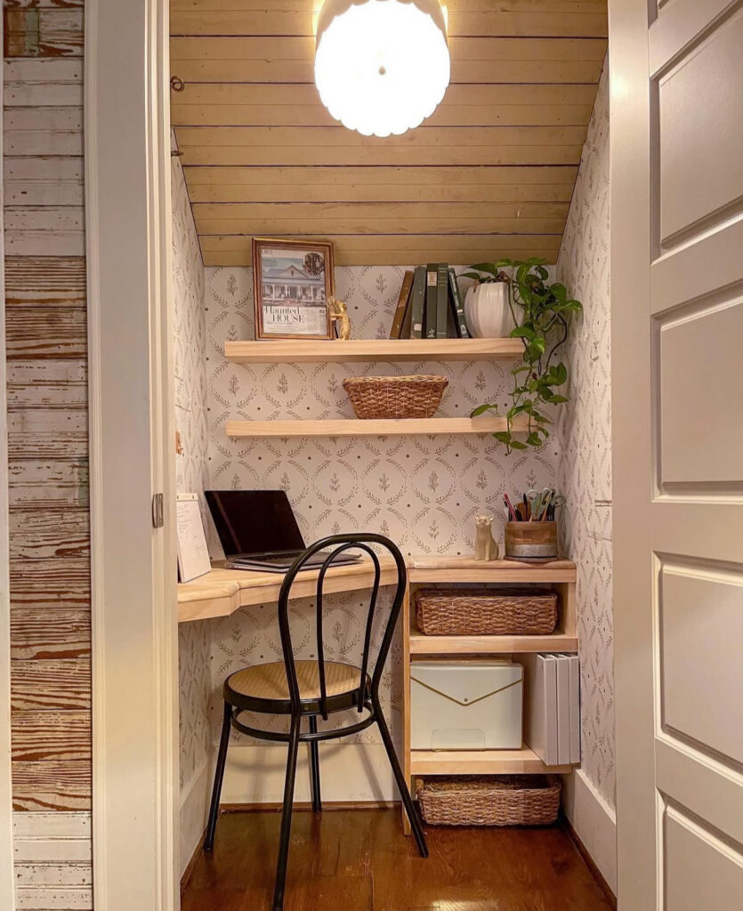 Closet-turned workspace with a warm wood desk, open shelves, and basket storage, cloffice design that hides clutter fast.