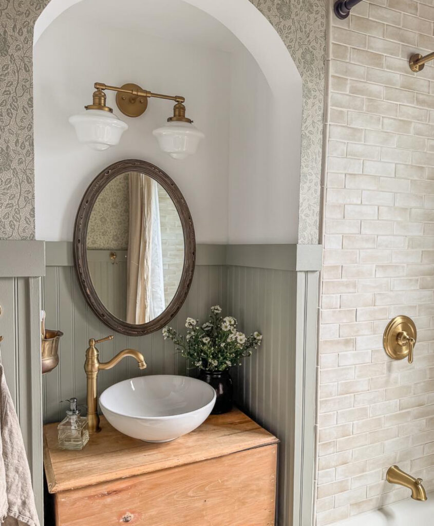 Storybook corner vintage bathroom with sage beadboard, vessel sink, and arched alcove.