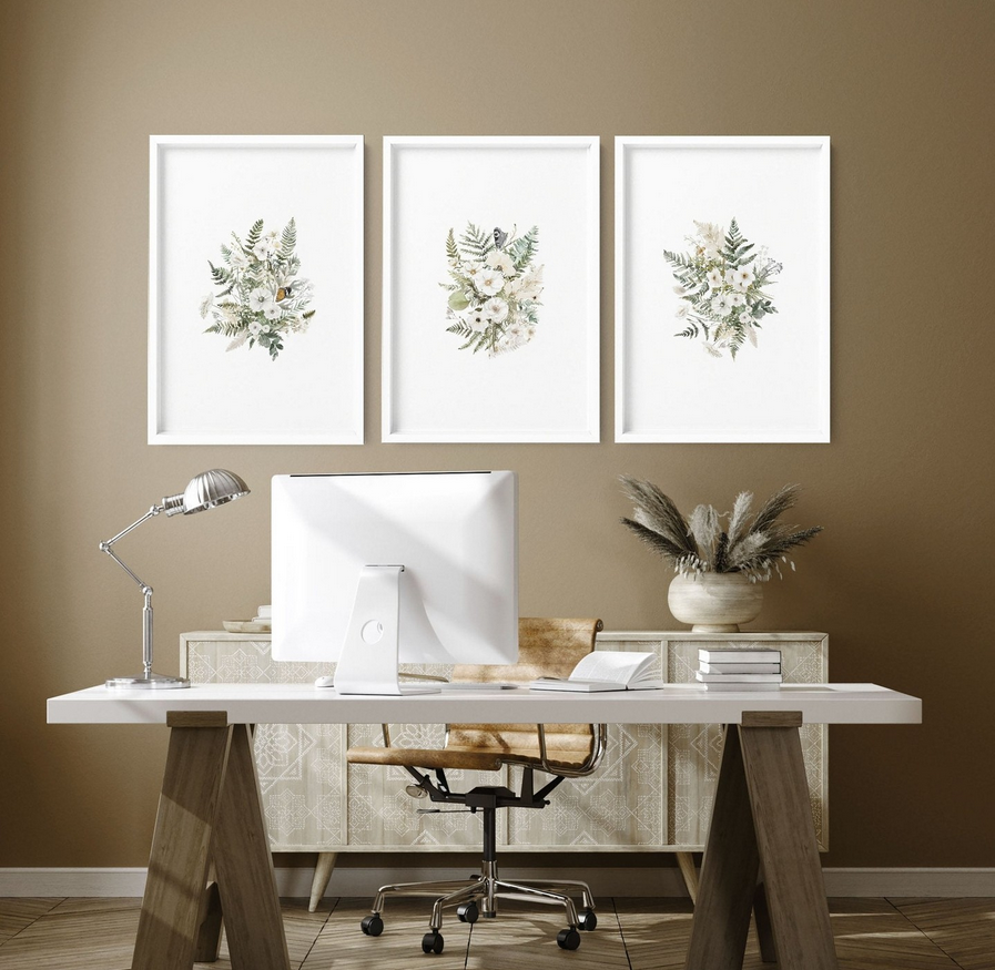 Inspirational office wall art in neutral tones decor: three botanical prints above a white desk with lamp and simple zen-inspired styling
