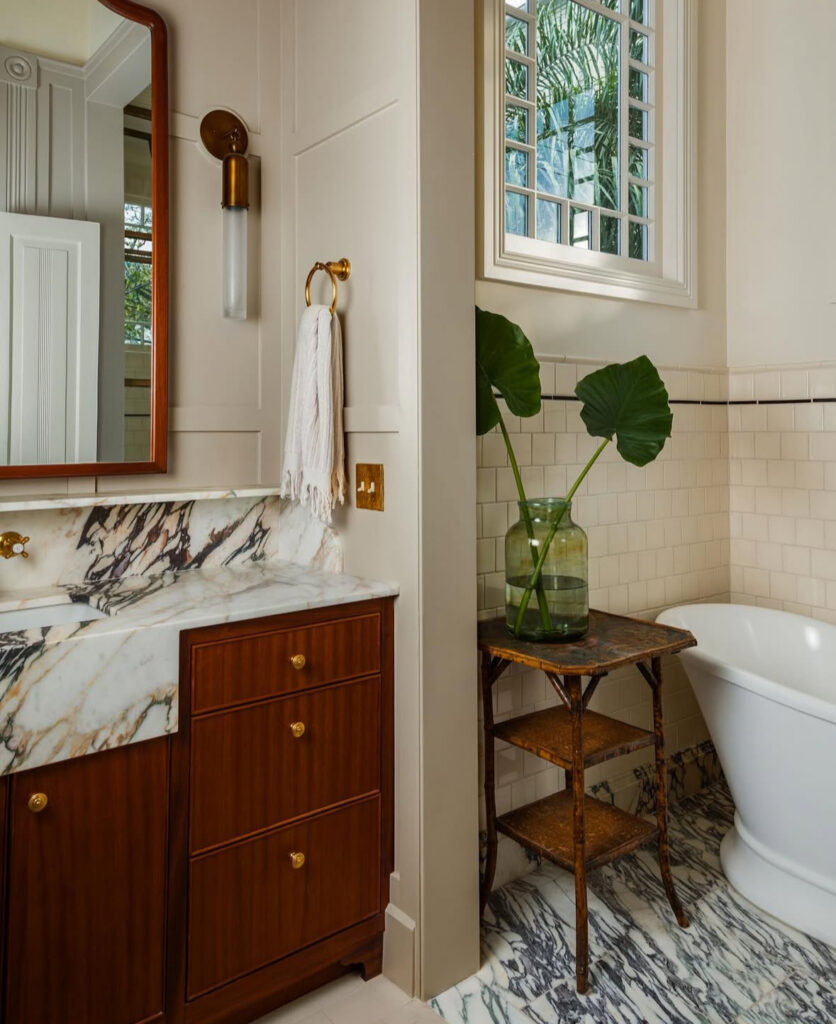 Bathroom decor with a rich mahogany vanity, dramatic marble countertop, and warm brass accents in a classic color palette.