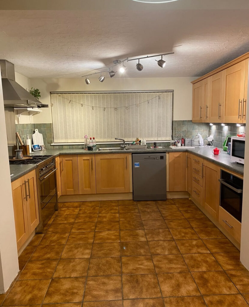 Family kitchen with orange floor tiles and wood cabinets before the soft blue refresh by @lizaprideaux.