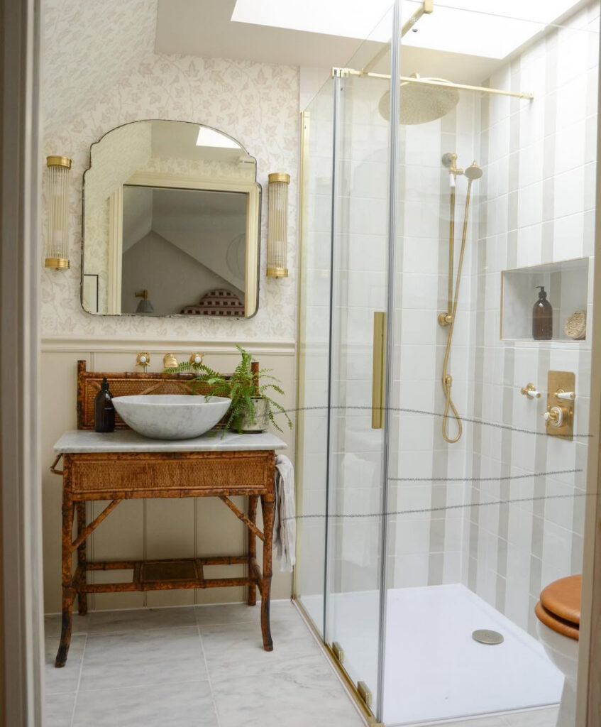 Walk-in shower room with a cane-front vanity and elegant vintage bathroom light fixtures flanking the mirror.