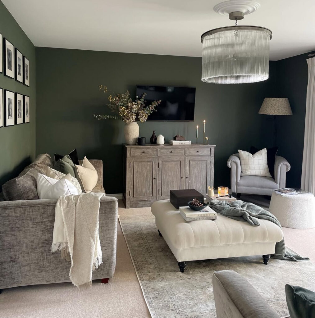 A cozy deep green living room styled with layered textures, warm lighting and budget-friendly decor pieces.