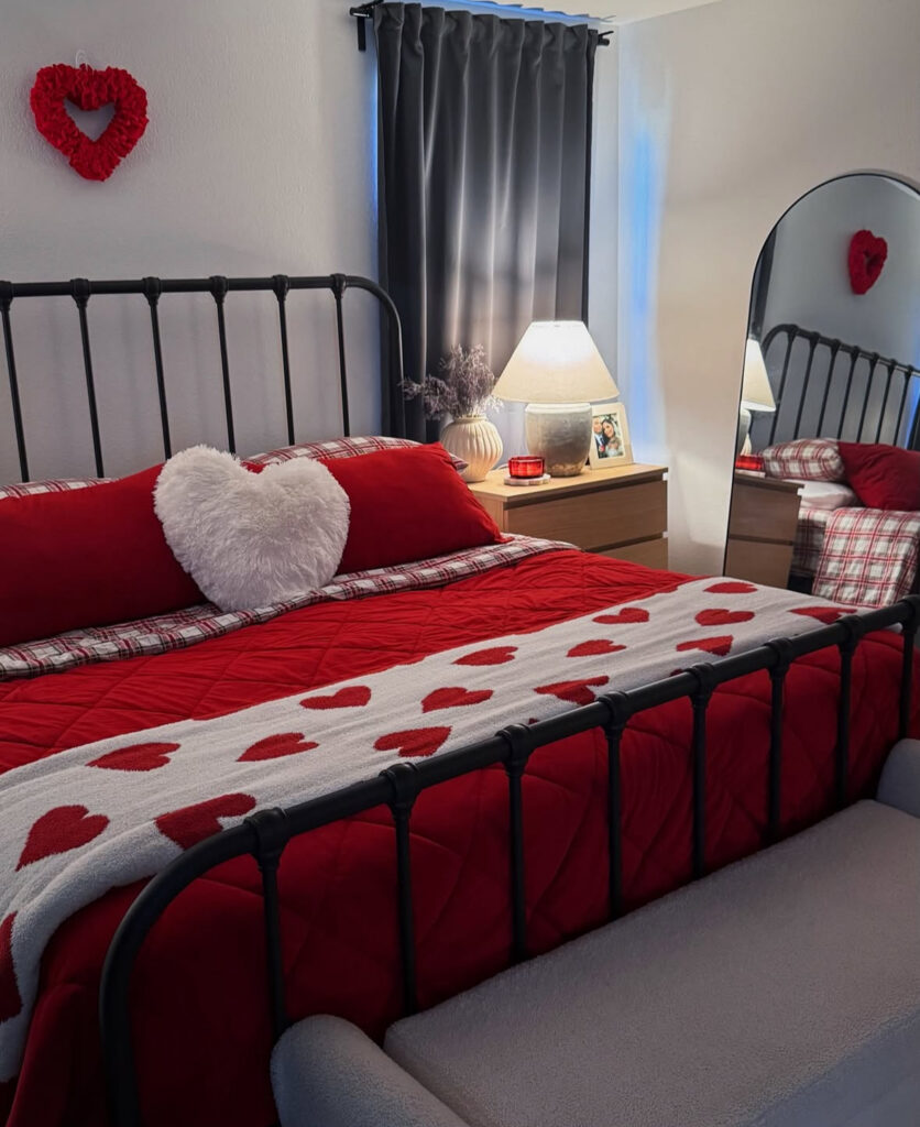 A cozy red and white bedroom with heart pillows and quilted bedding, perfect for valentines day bedroom ideas inspiration.