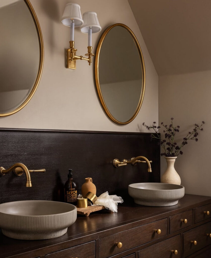 Earthy bathroom with an espresso stained wood vanity, unlacquered brass bathroom fixtures, and textured bowl sinks.