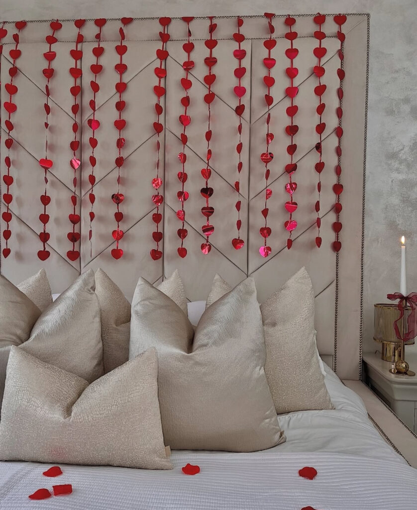 Glamorous bedroom with metallic heart garlands above the headboard showcasing romantic bedroom ideas for valentines day.
