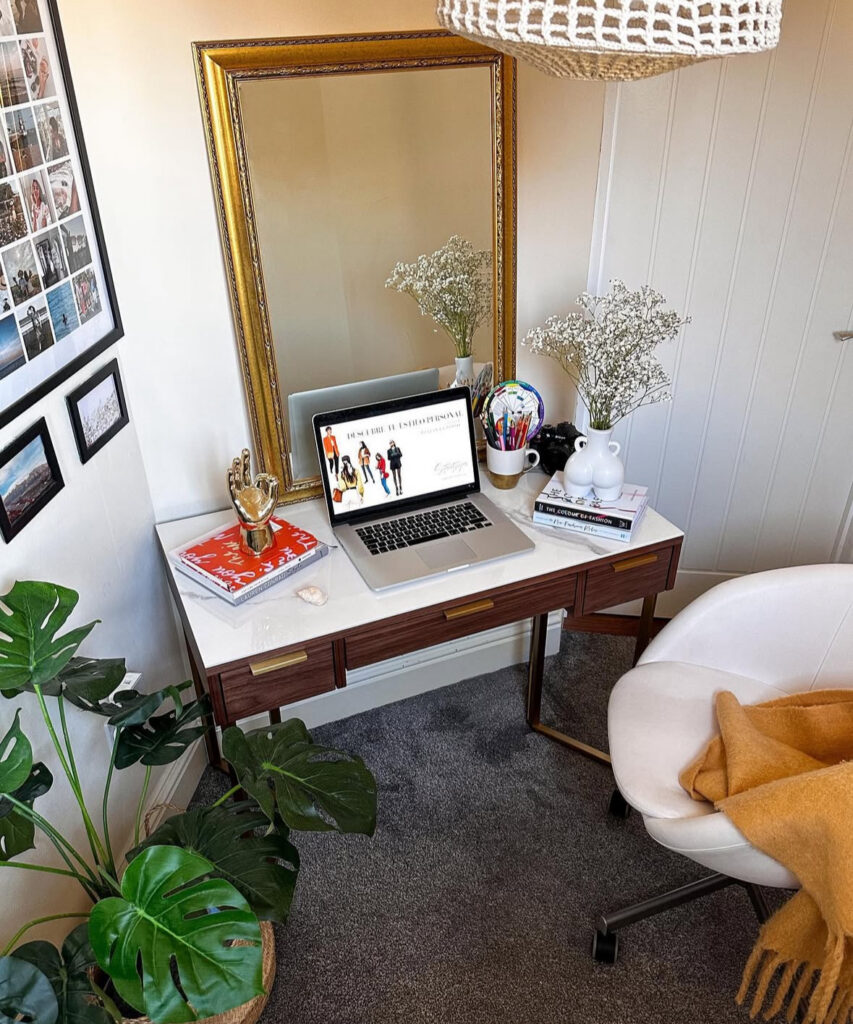 Hallway desk setup with a large gold mirror, simple styling, and a petite chair, hidden office space that feels polished.