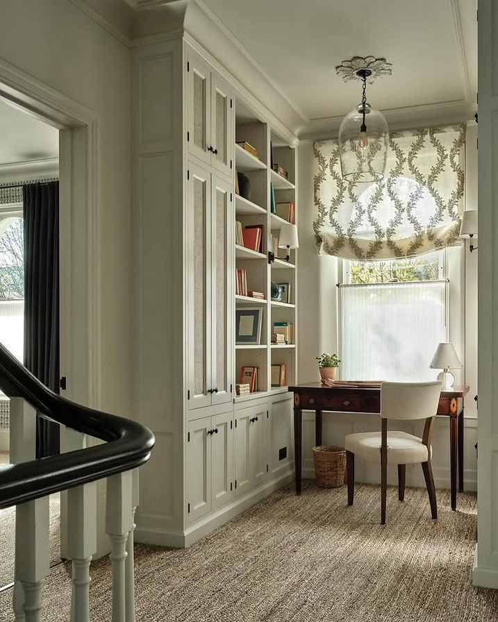 Built-in home office nook with white cabinets, warm wood uppers, and a slim desk with two chairs.