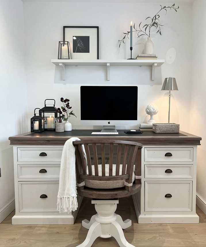 Farmhouse-style home office desk with a shelf above, lantern decor, and a mix of white and wood tones