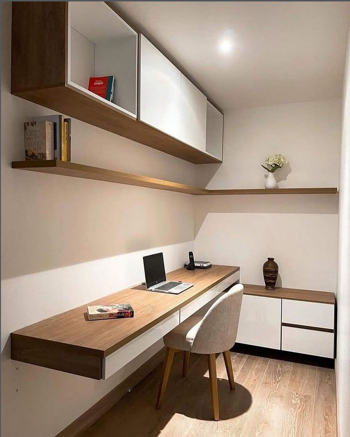 Home office desk with a slatted wood wall feature behind a wide monitor and a simple wood desktop.
