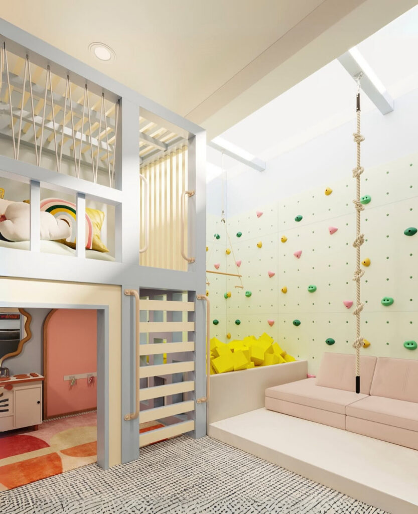 Indoor playroom activity zone with a loft, rope swing, climbing wall, foam pit, and soft seating designed for energetic play and quick cleanup.