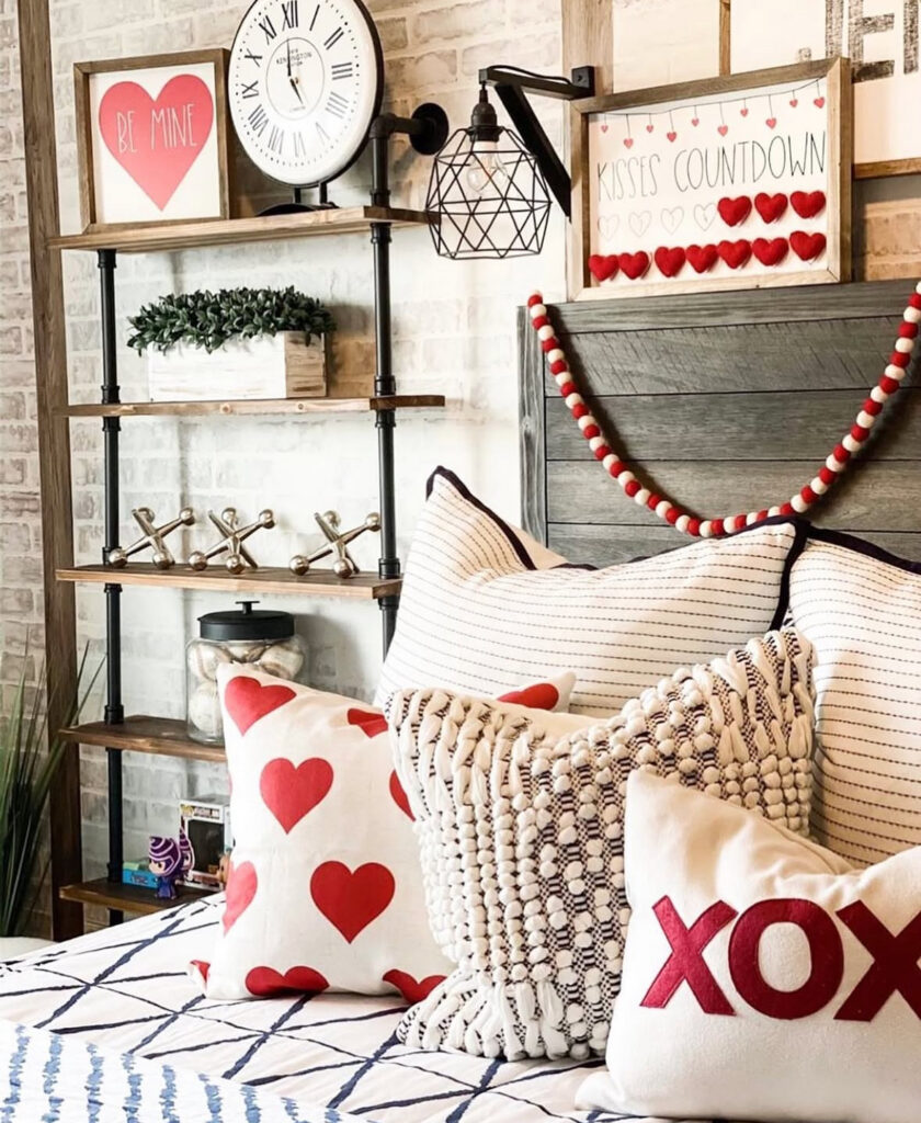 Modern industrial bedroom with red and white heart pillows and garland as fun valentines day bedroom decor inspiration.