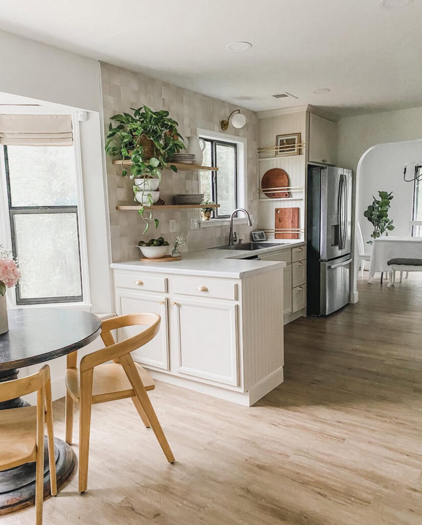 Updated galley kitchen with a smooth white ceiling, recessed spotlights and a soft pendant leading to an arched dining opening, renovated by @delancey.diy.