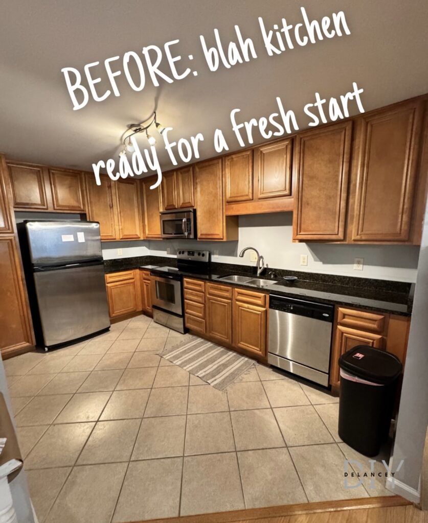 Orange-toned cabinets, black counters and diagonal beige tile before the sage green kitchen upgrades by @delancey.diy.