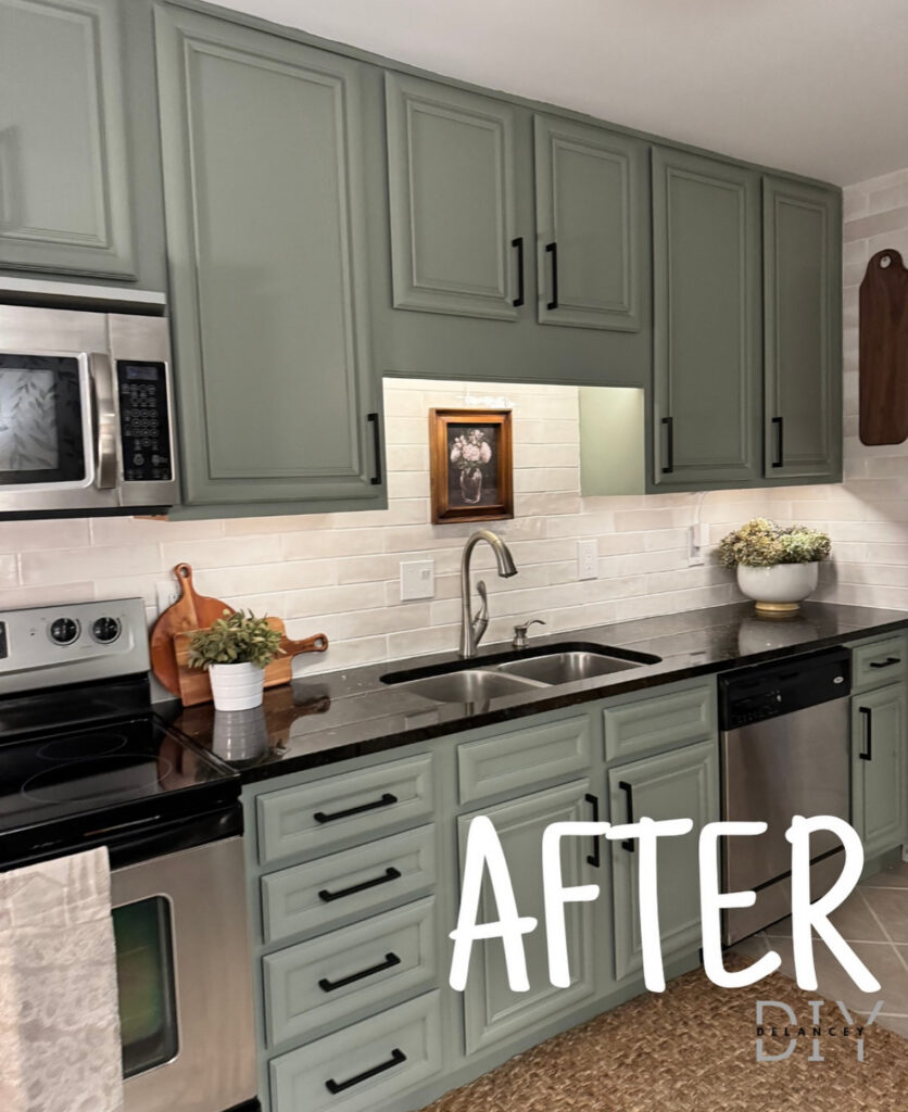 Sage green kitchen with matte black hardware, creamy subway backsplash and existing dark countertops now feeling fresh, updated by @delancey.diy.