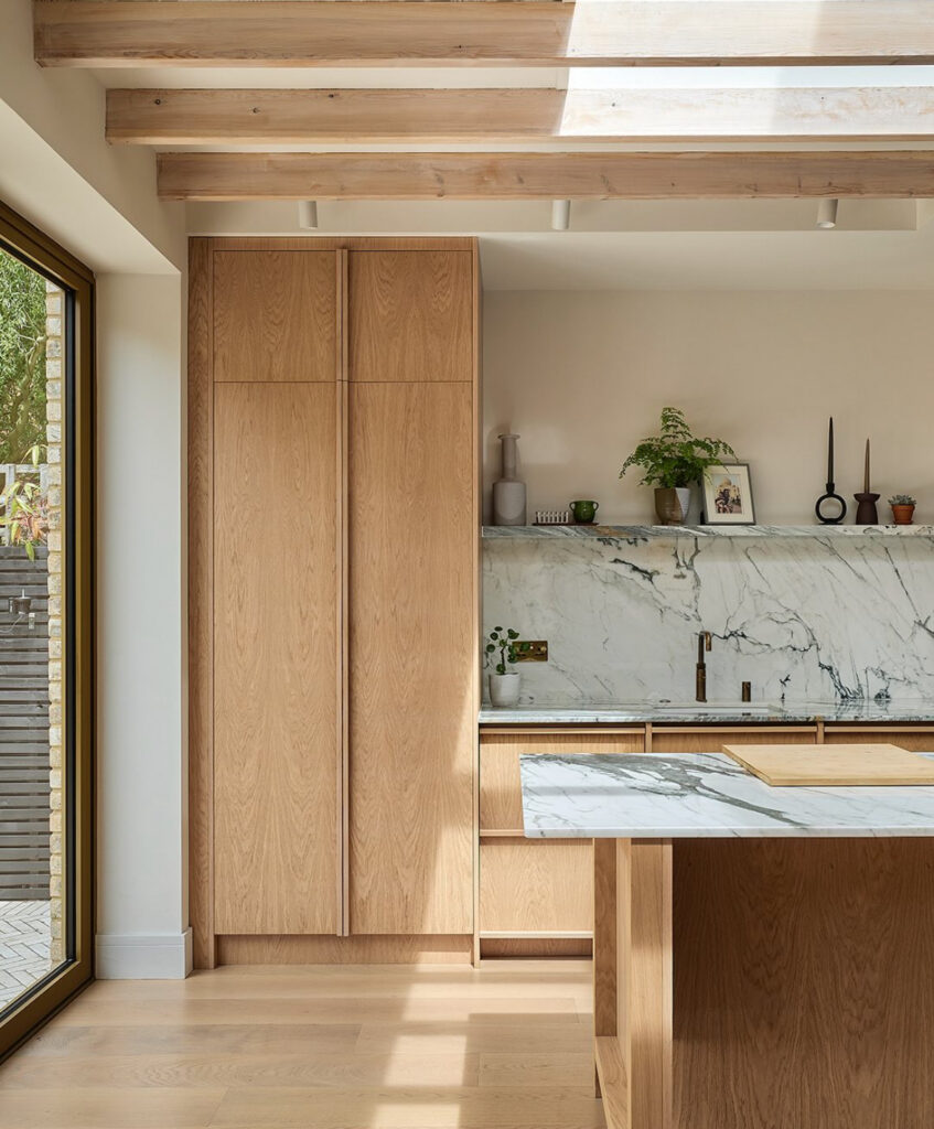 Light oak kitchen with dramatic marble backsplash and brass accents by Nordiska Kök in @devdesigns_leigh’s home, a warm light oak kitchen with Scandinavian flair.